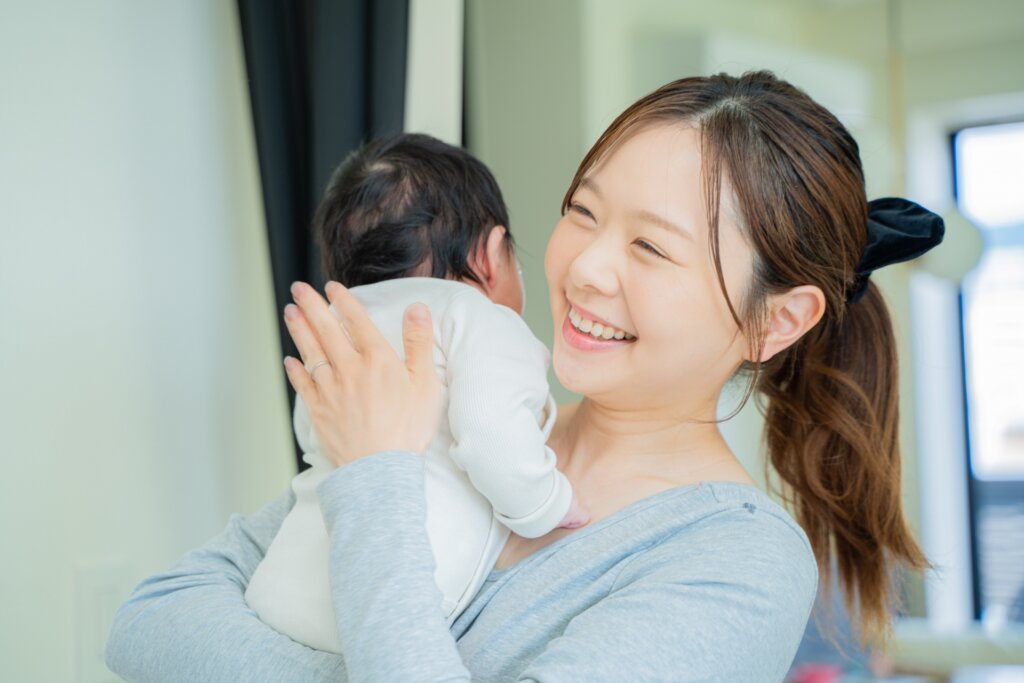 赤ちゃんの背中をトントンするお母さん
