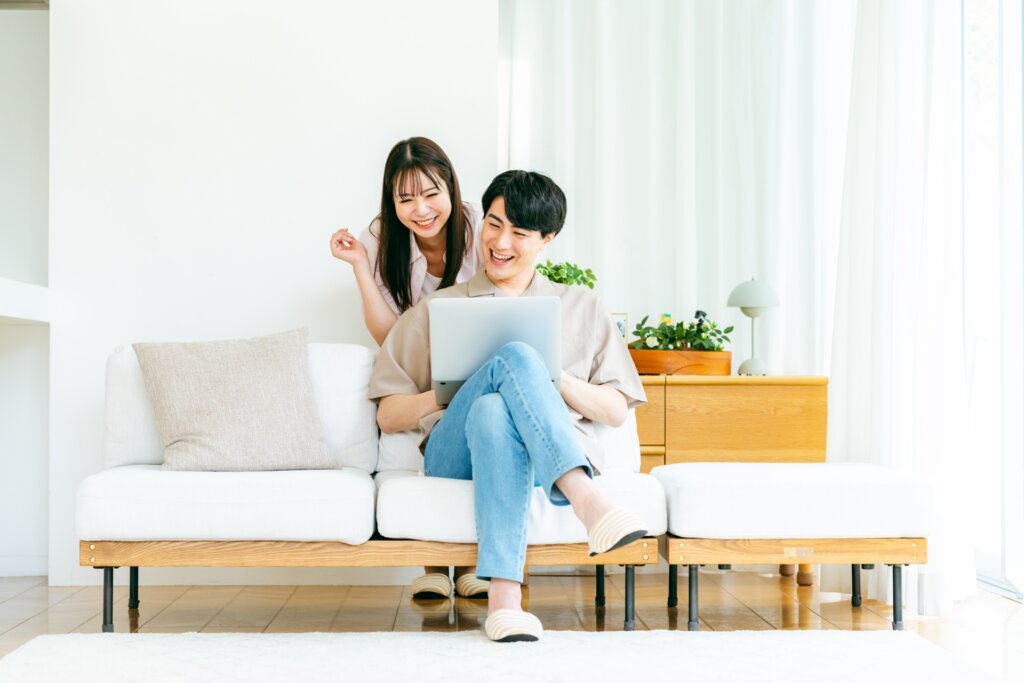 リビングでパソコンを見るカップル