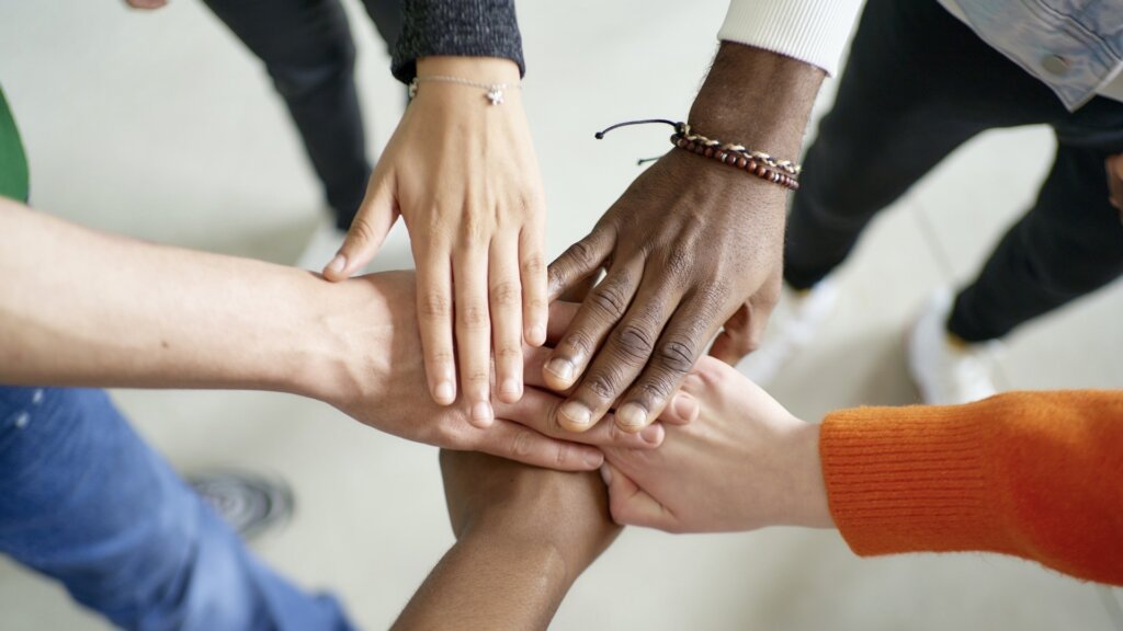 手を重ねる人々