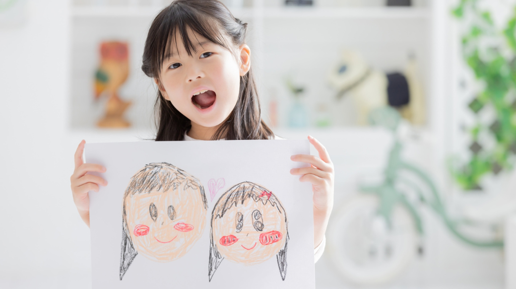 パパとママの似顔絵を描く女の子